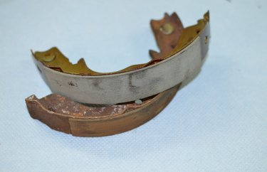 Старые и новые тормозные колодки стояночного тормоза Мицубиси Аутлендер